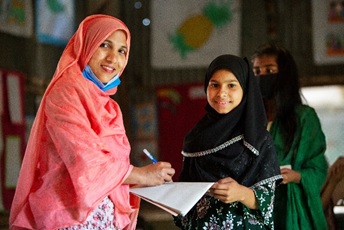 Takmina Akter in the classroom with her teacher.