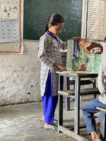 Salma demonstrating her work at the front of the classroom.