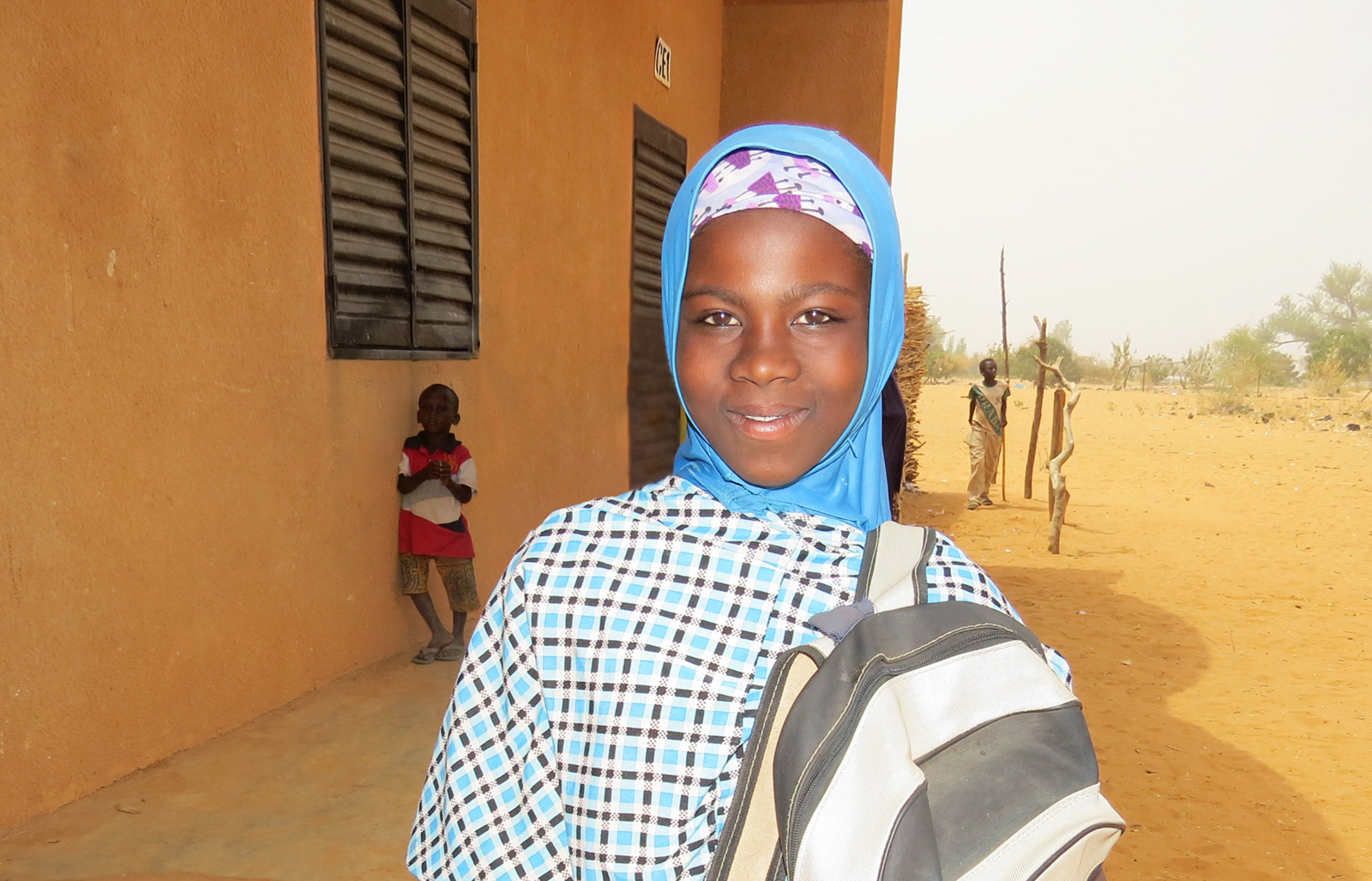 © Plan International, a girl in the school yard.